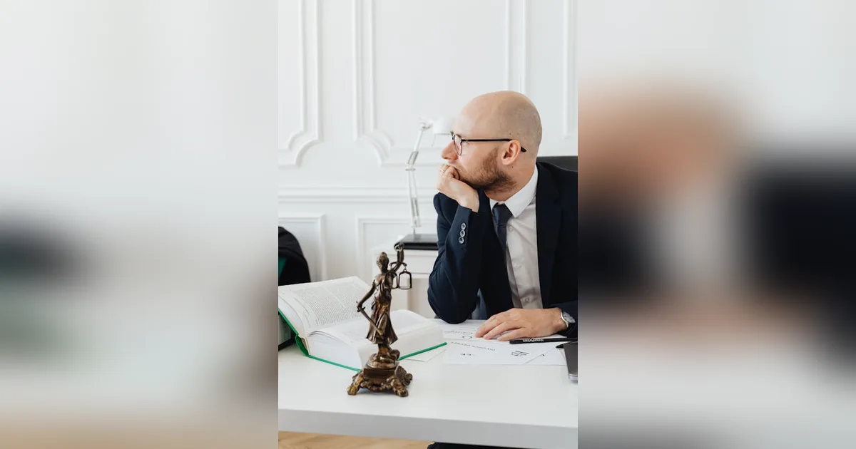 Estatua de Temida sobre escritorio con documentos legales representando análisis jurisprudencial